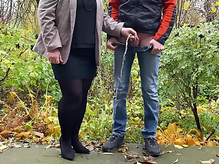 Hot milf in pantyhose and main holding guy's cock outdoors while pissing